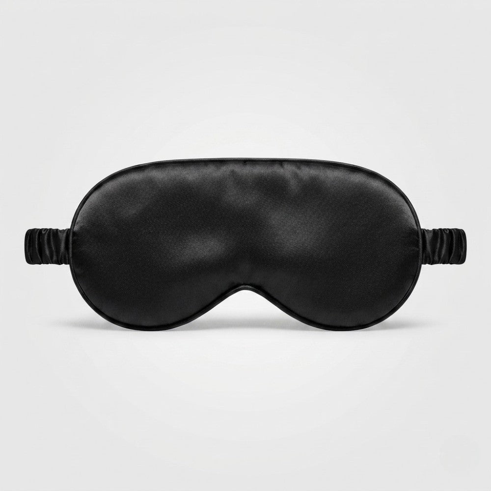 Black silk sleep mask with eye cups on a light gray background