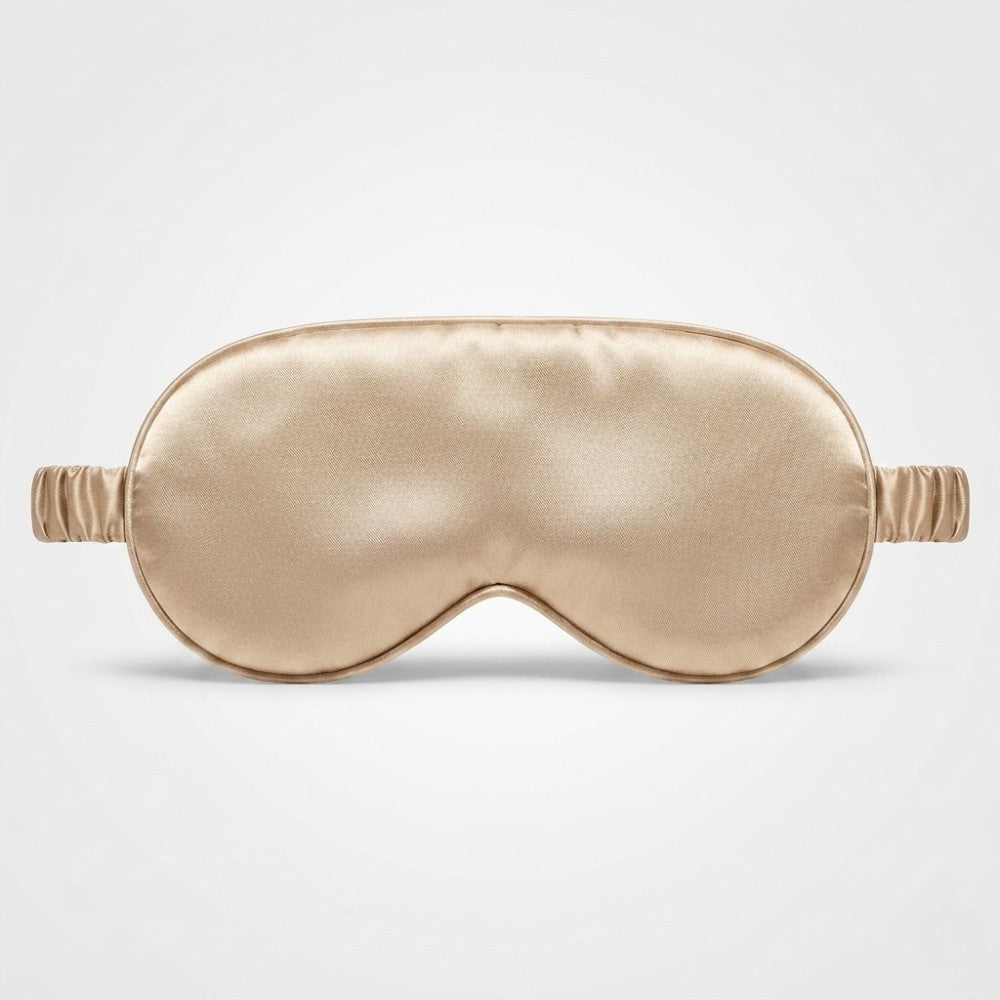 Champagne gold silk sleep mask with  eye cups on a light gray background