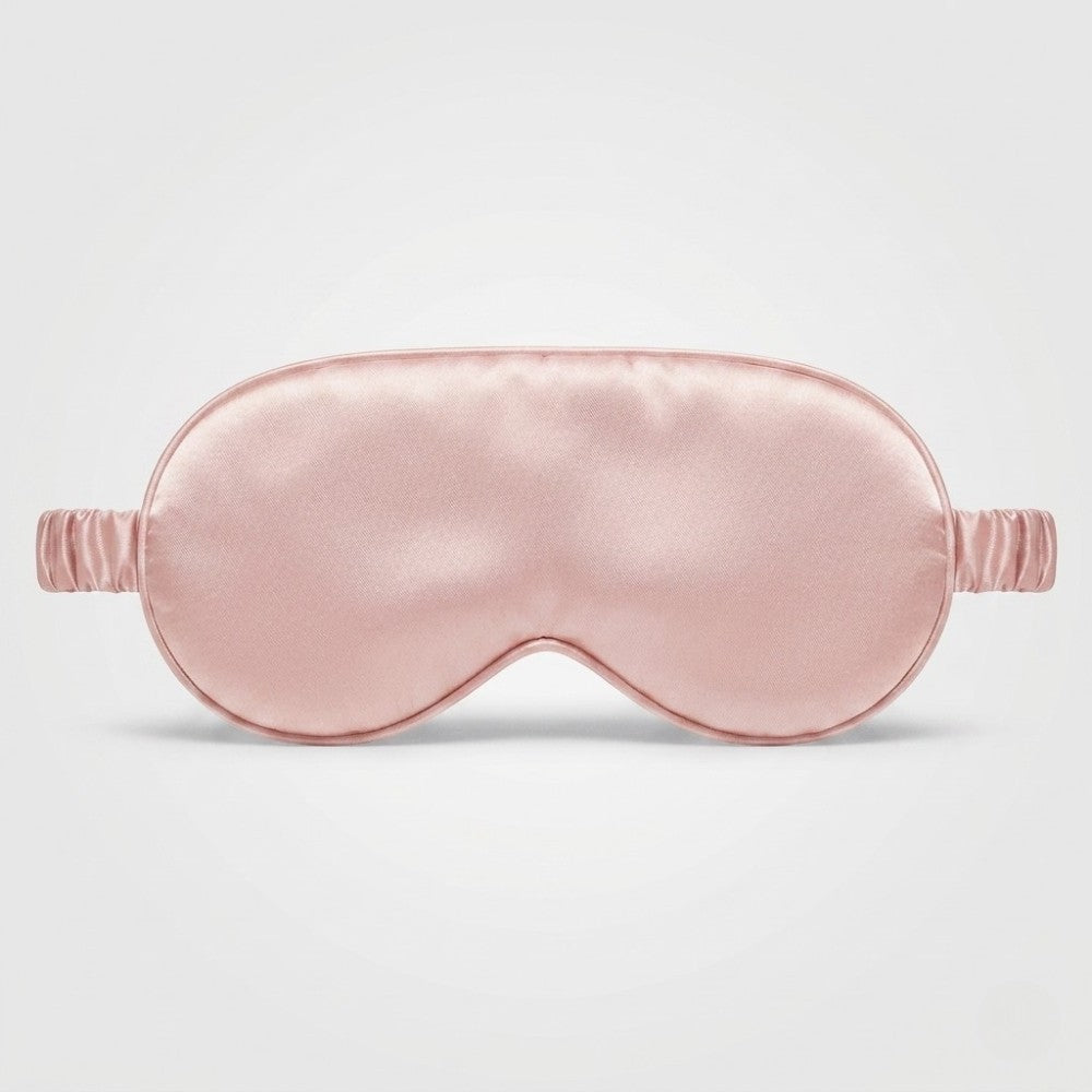 Pink silk sleep mask on a light gray background