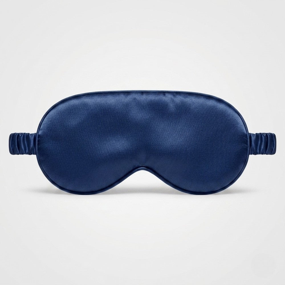 Navy blue silk sleep mask on a light gray background