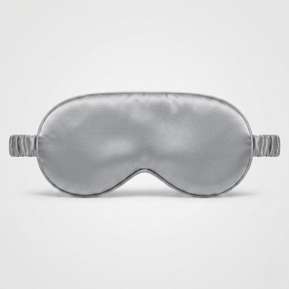 Silver silk sleep mask on a light gray background