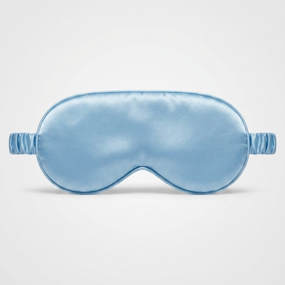 Blue silk sleep mask on a light gray background
