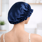 Back view of a woman wearing a navy blue silk bonnet in a blurred indoor setting