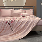 Bed with pink floral silk bedding and pillows in a bedroom setting.