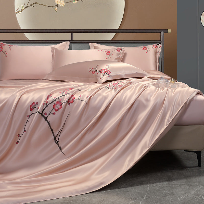 Bed with pink silk floral bedding and pillows in a bedroom setting.