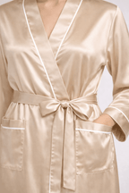 Beige silk robe with white piping on a light gray background