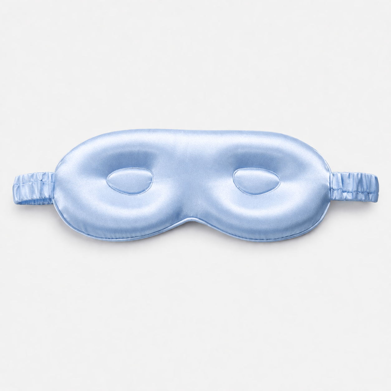 Blue silk eye mask with contour on a light gray background
