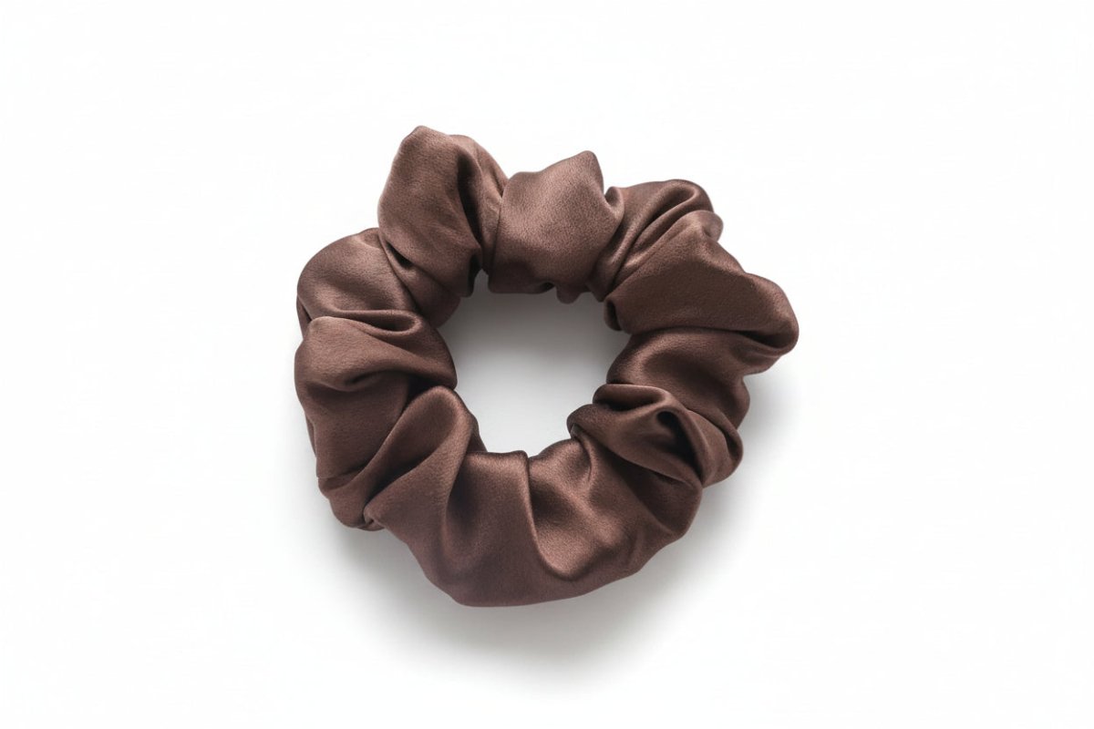 Brown silk scrunchie on a white surface