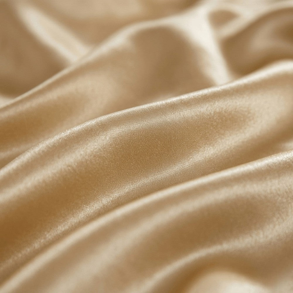 Close-up of champagne gold silk fabric with soft folds