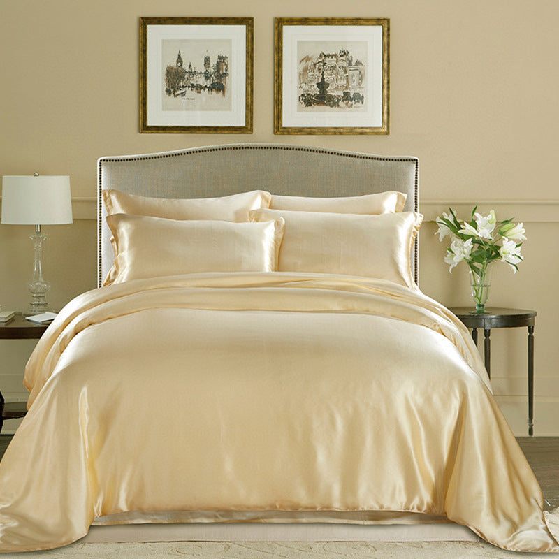 Champagne gold silk duvet cover on a bed with framed artwork on the wall.