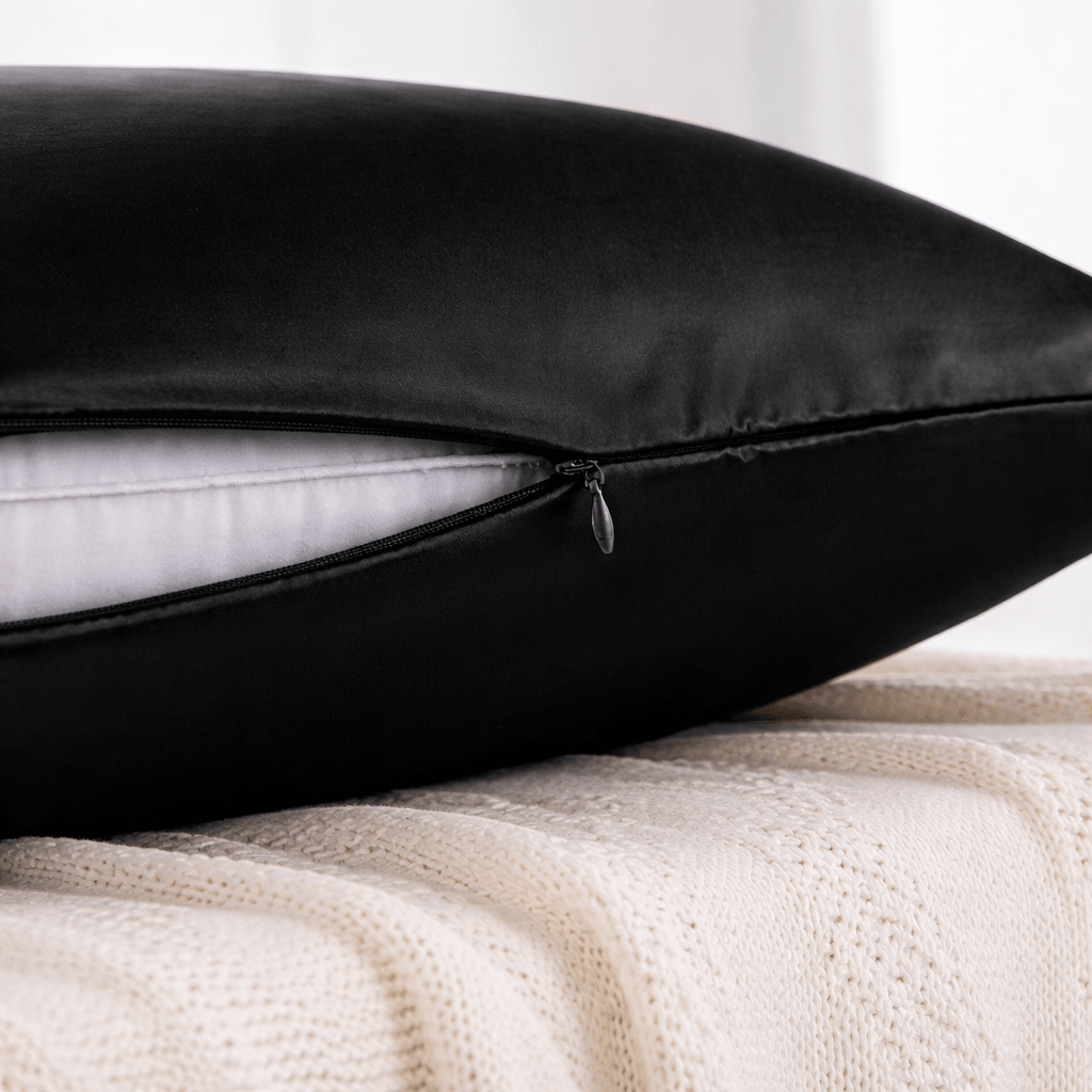 Close-up of a black pillowcase with a zipper on a white background