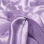 Close-up of a purple silk fabric with floral embroidery
