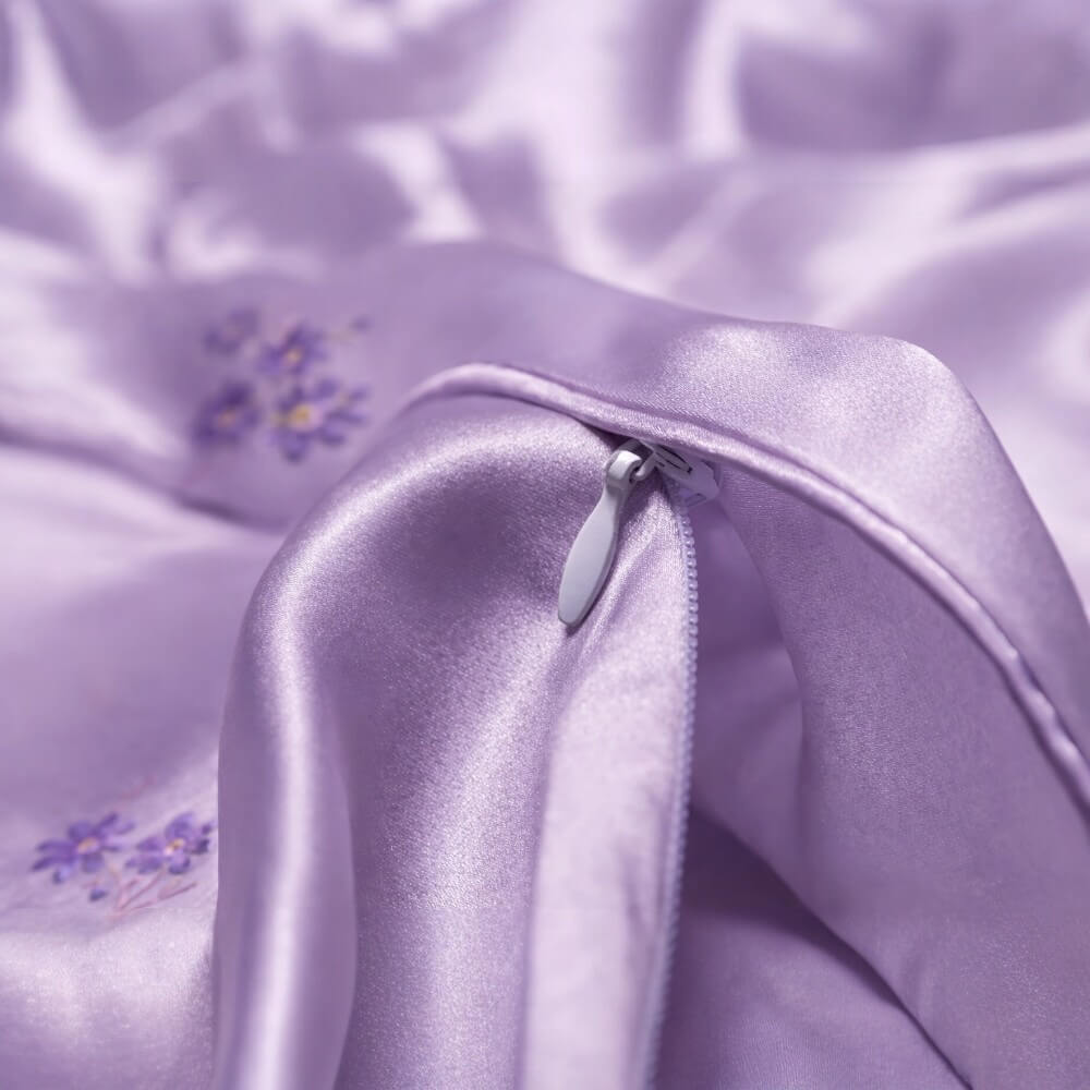 Close-up of a purple silk fabric with floral embroidery