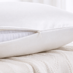 Close-up of a white silk pillowcase on a textured beige surface