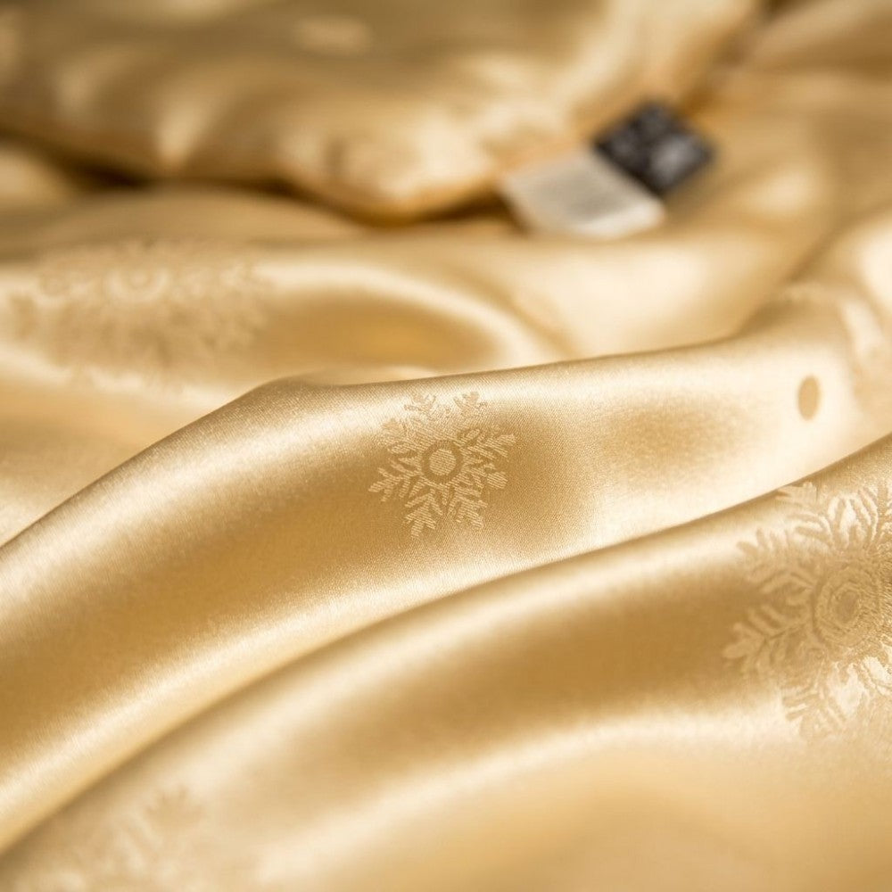 Close-up of gold fabric with a subtle snowflake pattern.