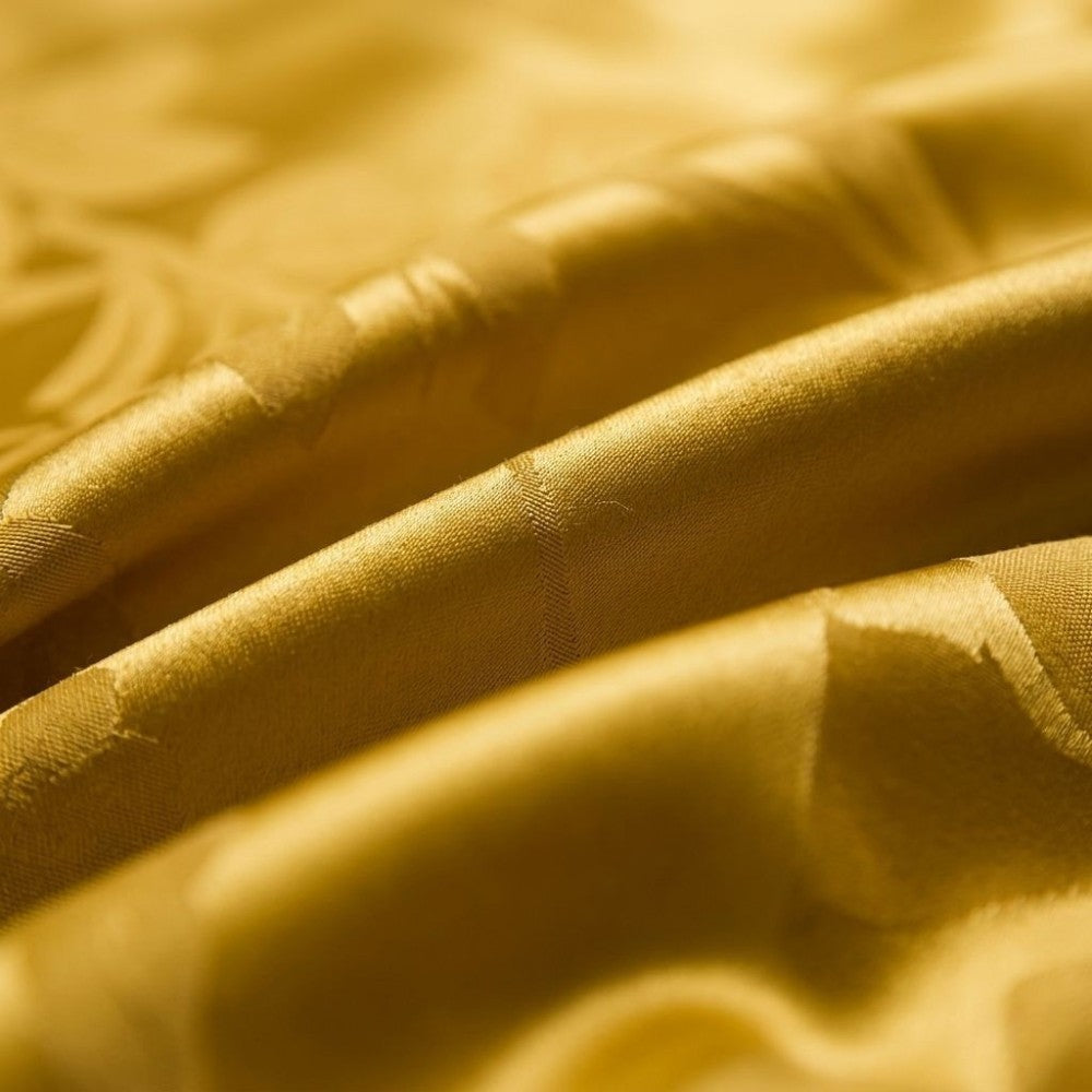 Close-up of textured yellow silk fabric with intricate patterns