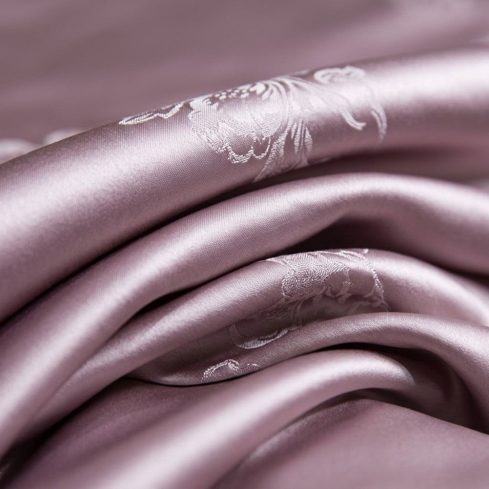 Close-up of light purple silk fabric with subtle floral embroidery