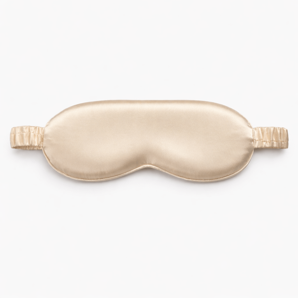 Contoured champagne gold sleep mask on a white background