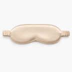 Contoured champagne gold sleep mask on a white background