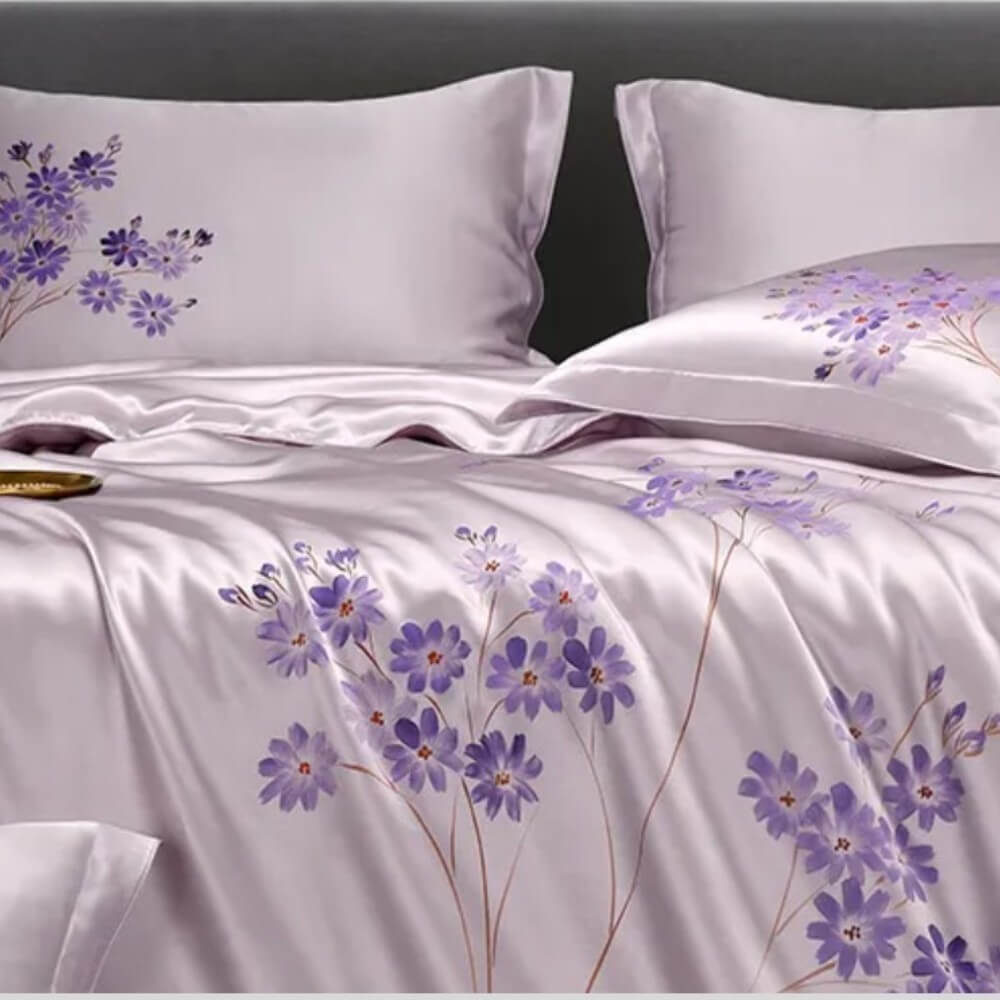 Floral-patterned bedspread with purple flowers on a white background