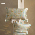 Floral patterned pillow and silk cover on a decorative stand against a beige background