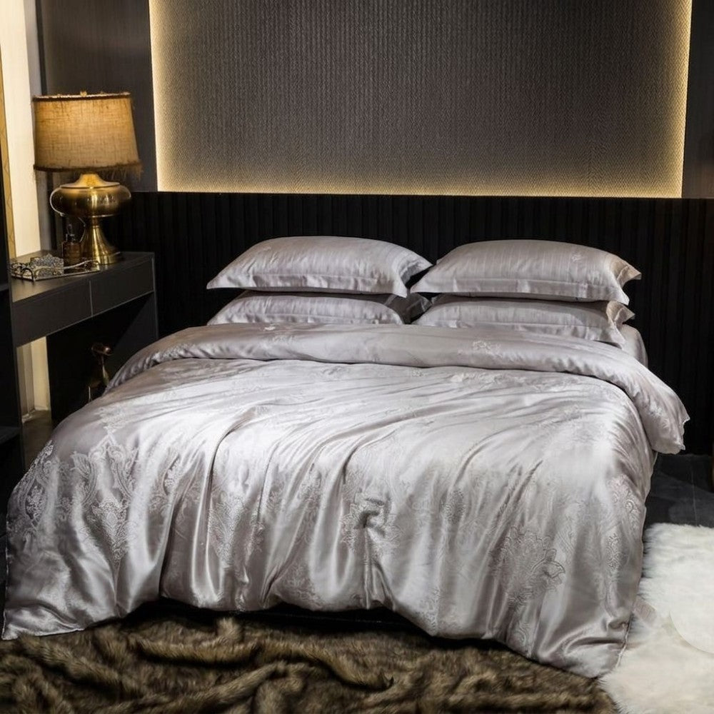 Bed with silver gray bedding in a bedroom setting