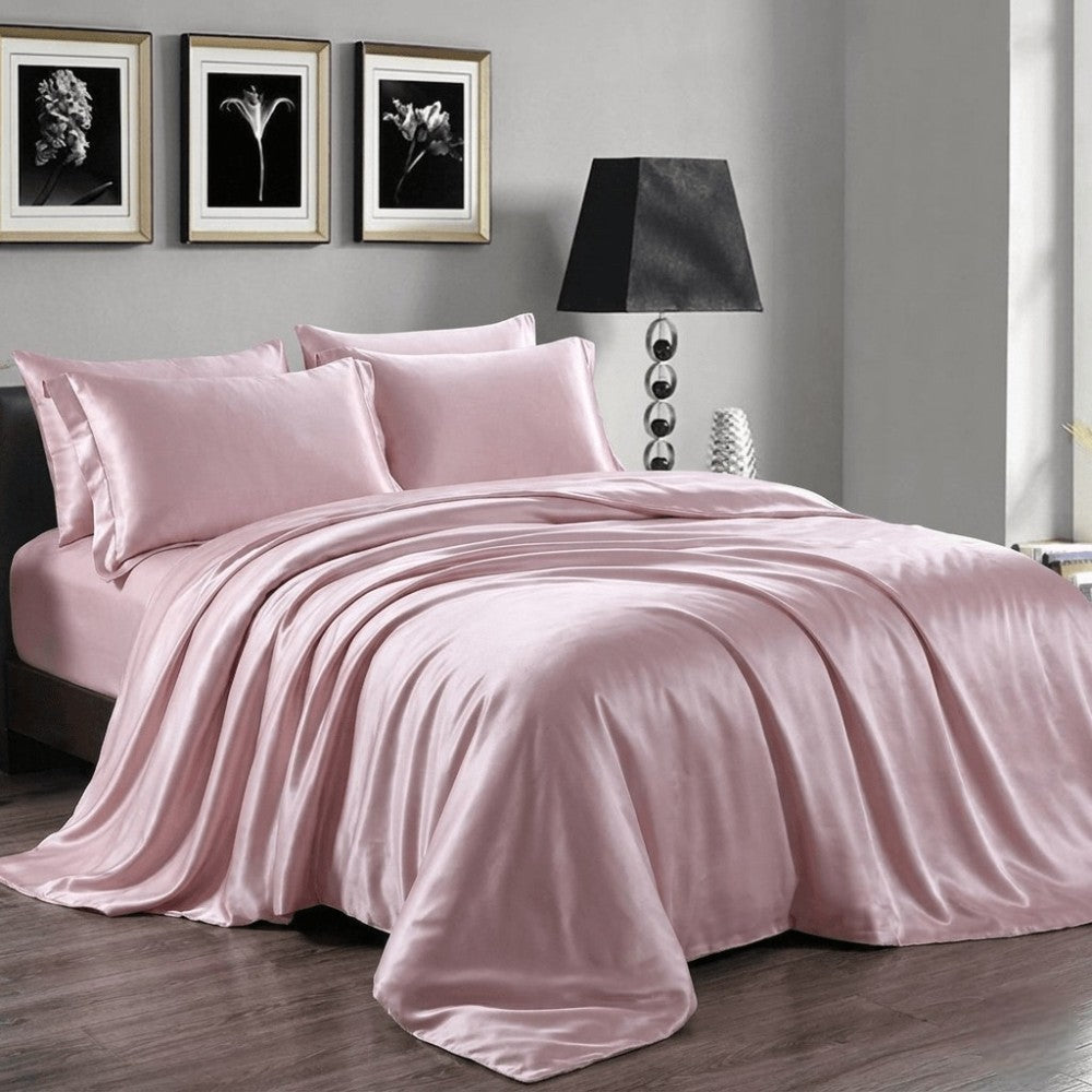Light purple silk duvet cover on a bed in a bedroom with framed artwork on the wall.