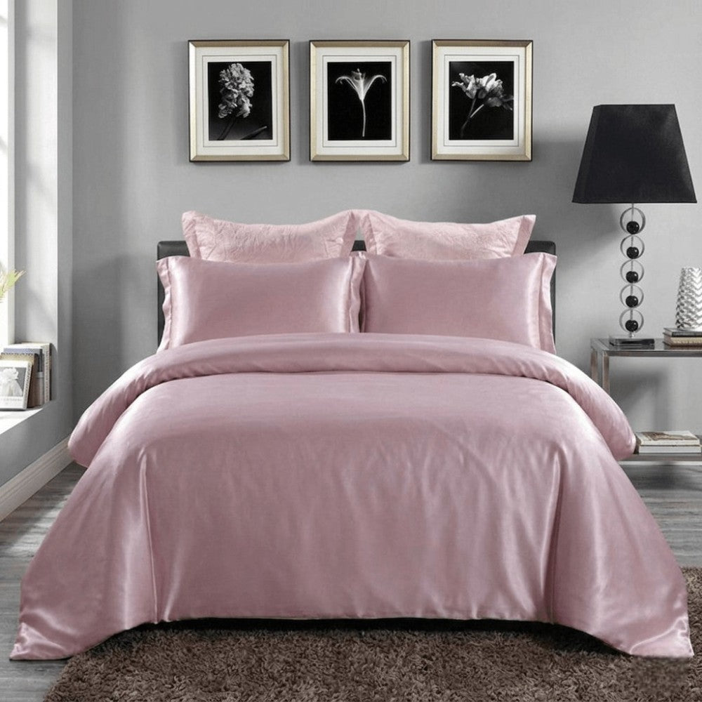 Light purple silk bedding set on a bed in a bedroom with framed pictures on the wall.