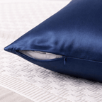 Navy blue silk pillowcase on a textured white surface