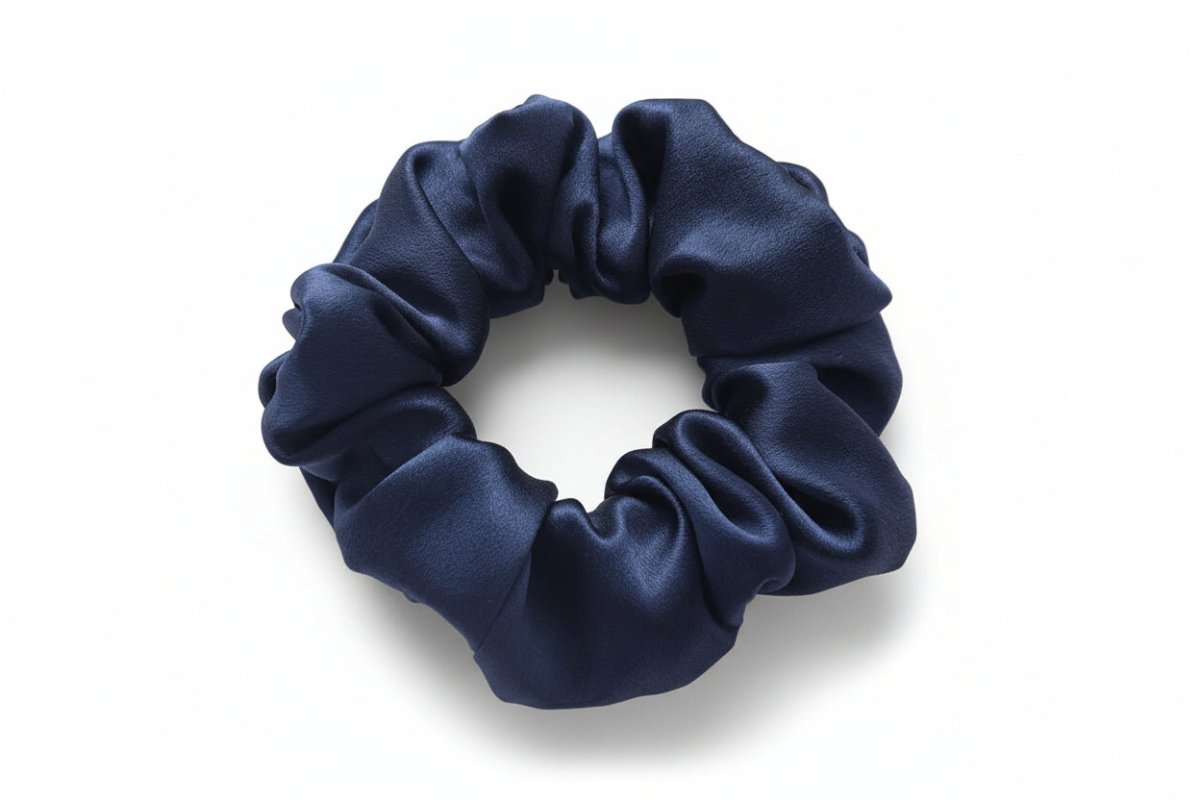 Navy blue silk scrunchie on a white background