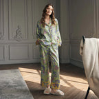 Woman wearing a floral silk pajama set in a sunlit room.