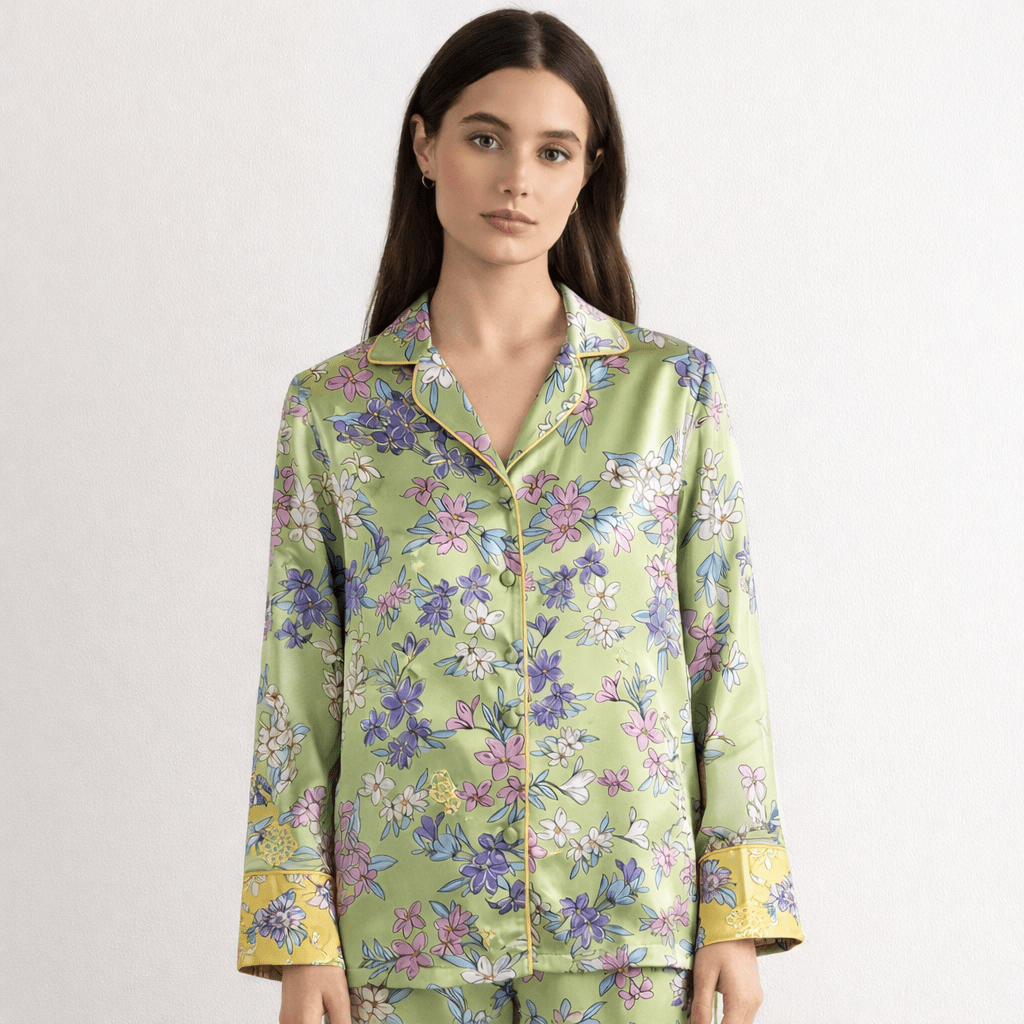 Woman wearing a floral silk pajama set on a white background