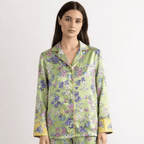 Woman wearing a floral silk pajama set on a white background