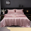 Pink silk bedding set on a bed in a dark-themed bedroom.
