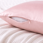 Pink silk pillowcase on a textured white surface