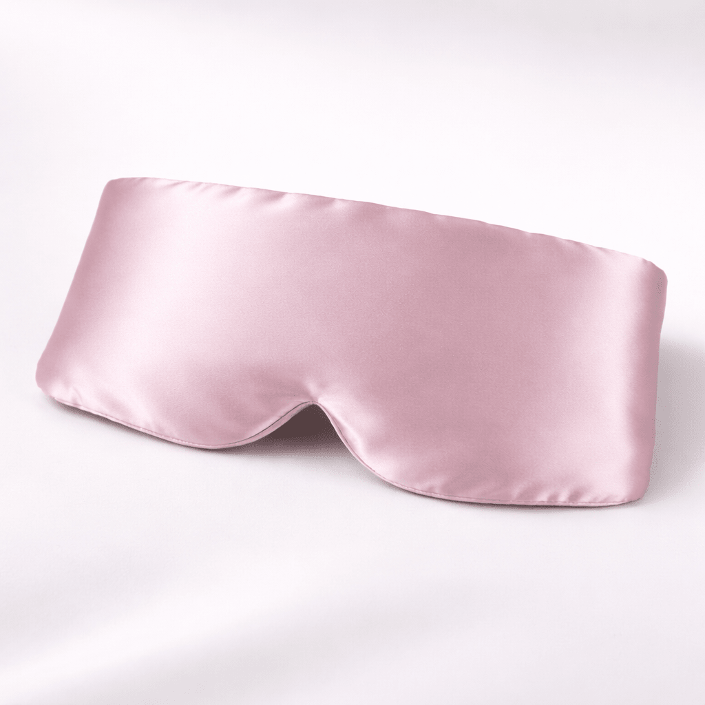 Pink silk sleep mask on a white background
