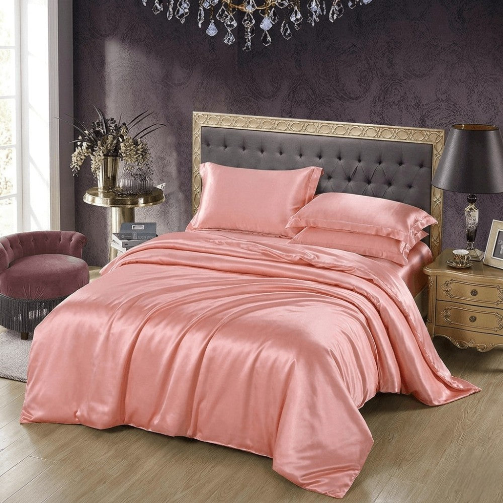 Pink silk bedding set on a bed in a stylish bedroom with decorative elements.