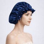 Side view of woman wearing a navy blue silk bonnet on a light gray background