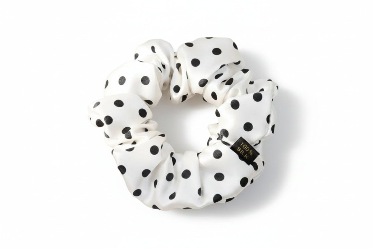 White scrunchie with black polka dots on a light beige background