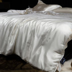 White silk comforter with floral embroidery on a bed