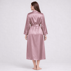 Woman wearing a pink silk robe on a white background