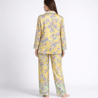 Woman wearing a yellow floral pajama set on a white background