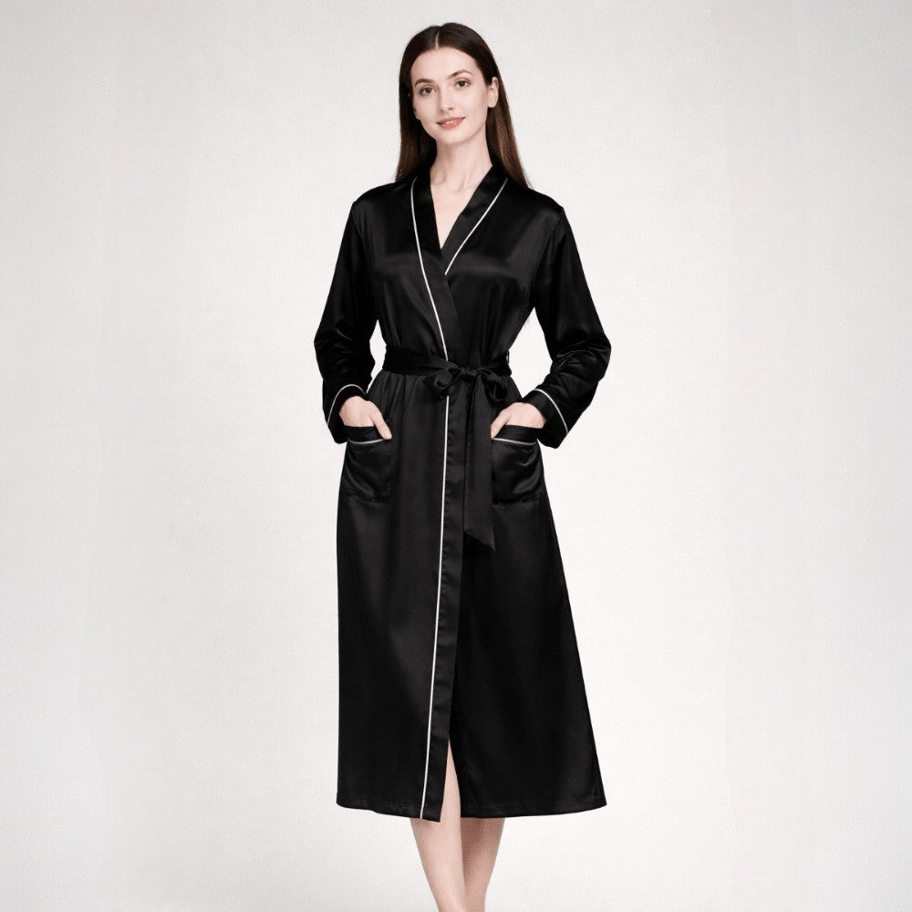 Woman wearing a black silk robe with white piping on a white background