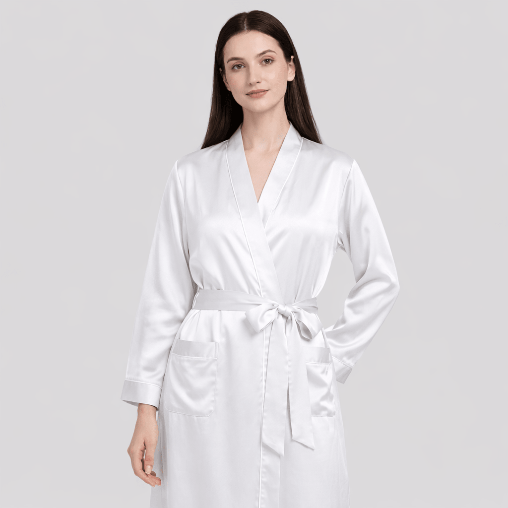 Woman wearing a white silk robe on a light gray background