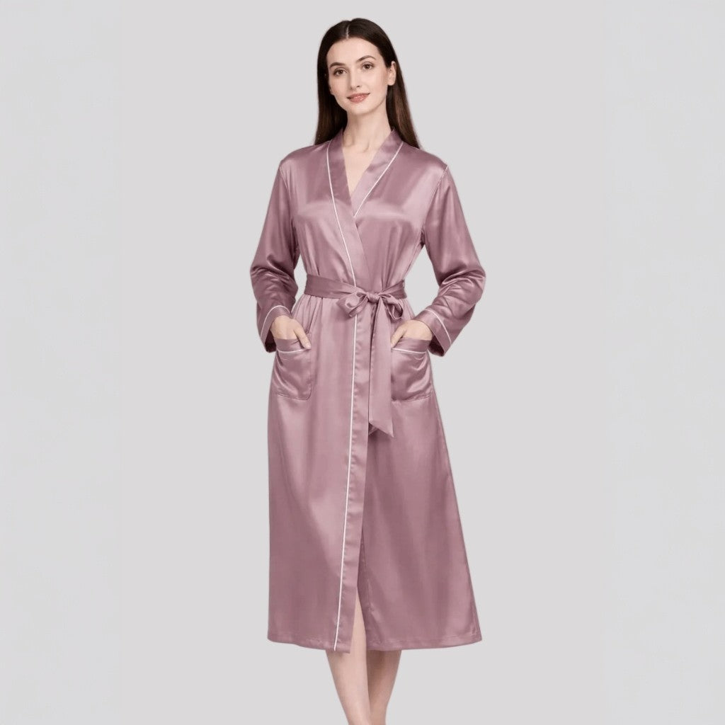 Woman wearing a dusty pink silk robe on a light gray background