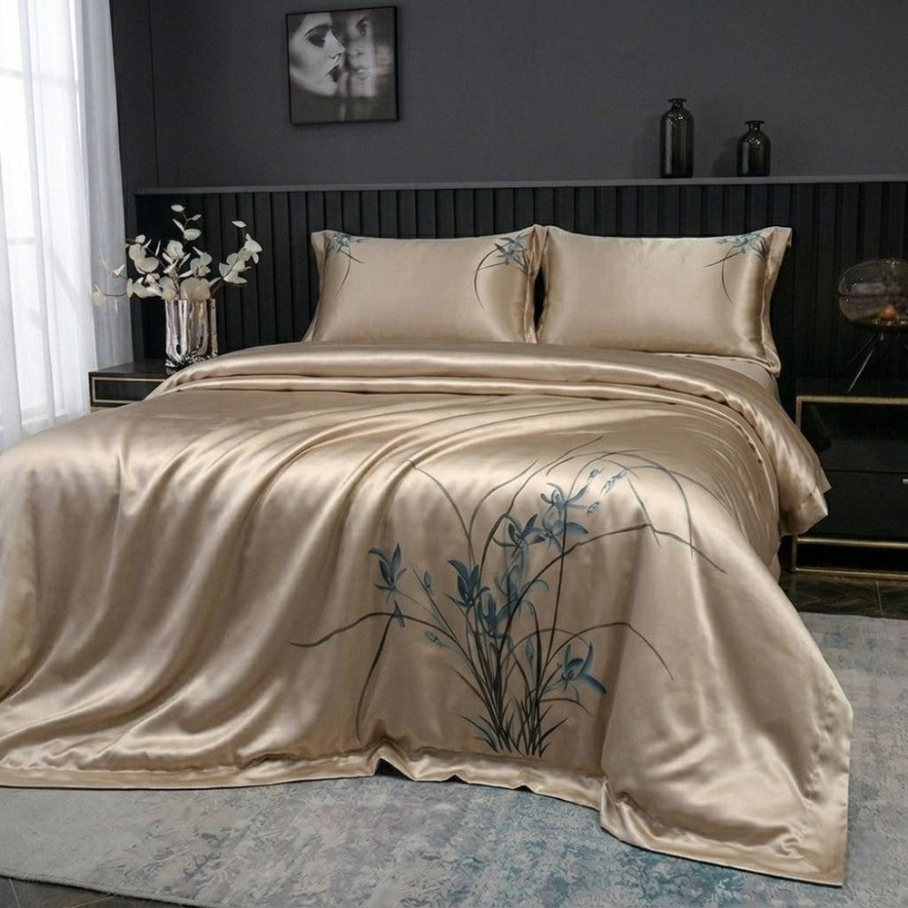 Beige satin bedding set with floral embroidery on a bed in a bedroom.