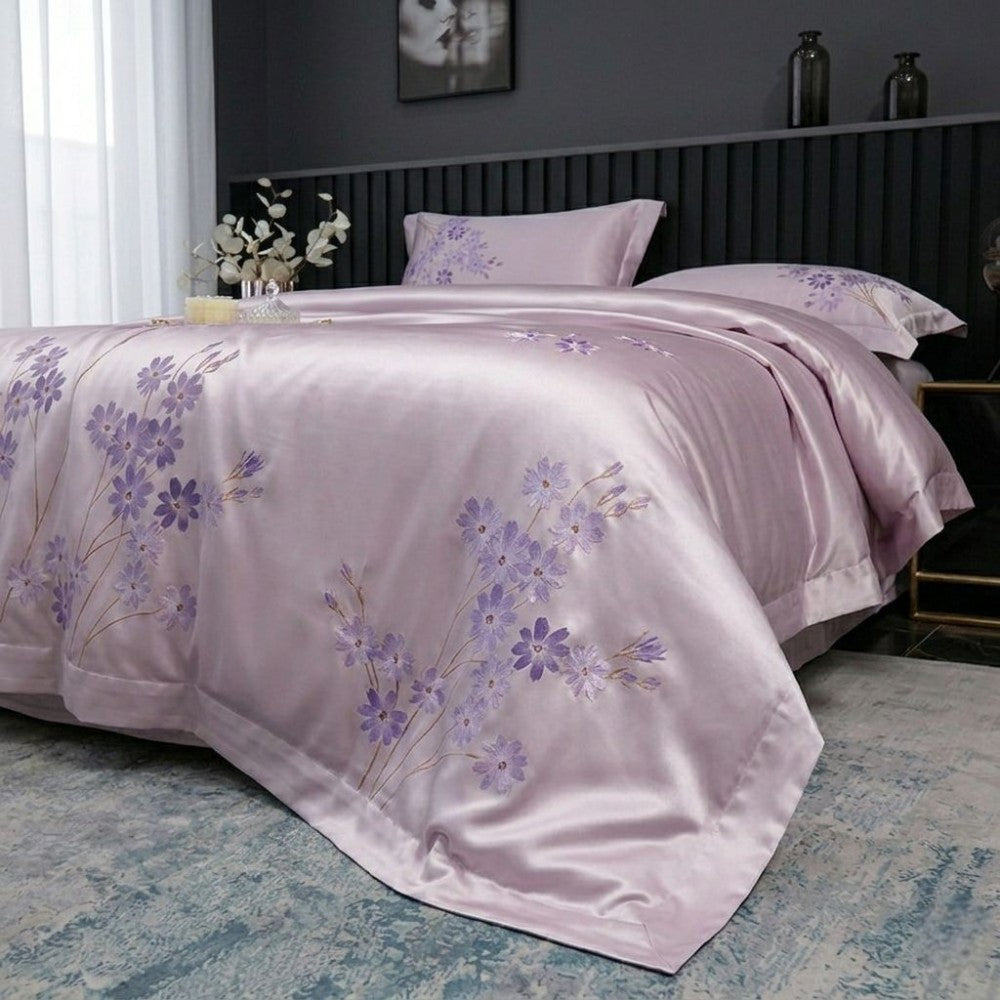 Purple floral bedspread on a bed in a bedroom setting