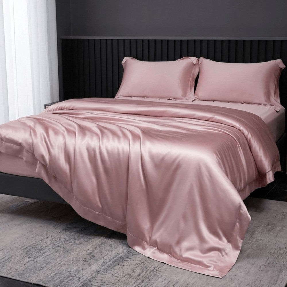 Pink silk duvet cover on a bed in a bedroom setting.