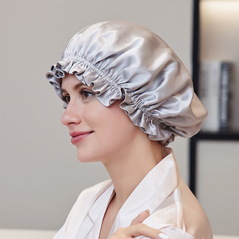 Woman wearing a champagne gold silk hair bonnet in a neutral setting