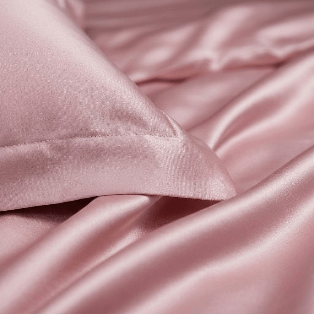 Close-up of pink silk pillowcase fabric with a pillow